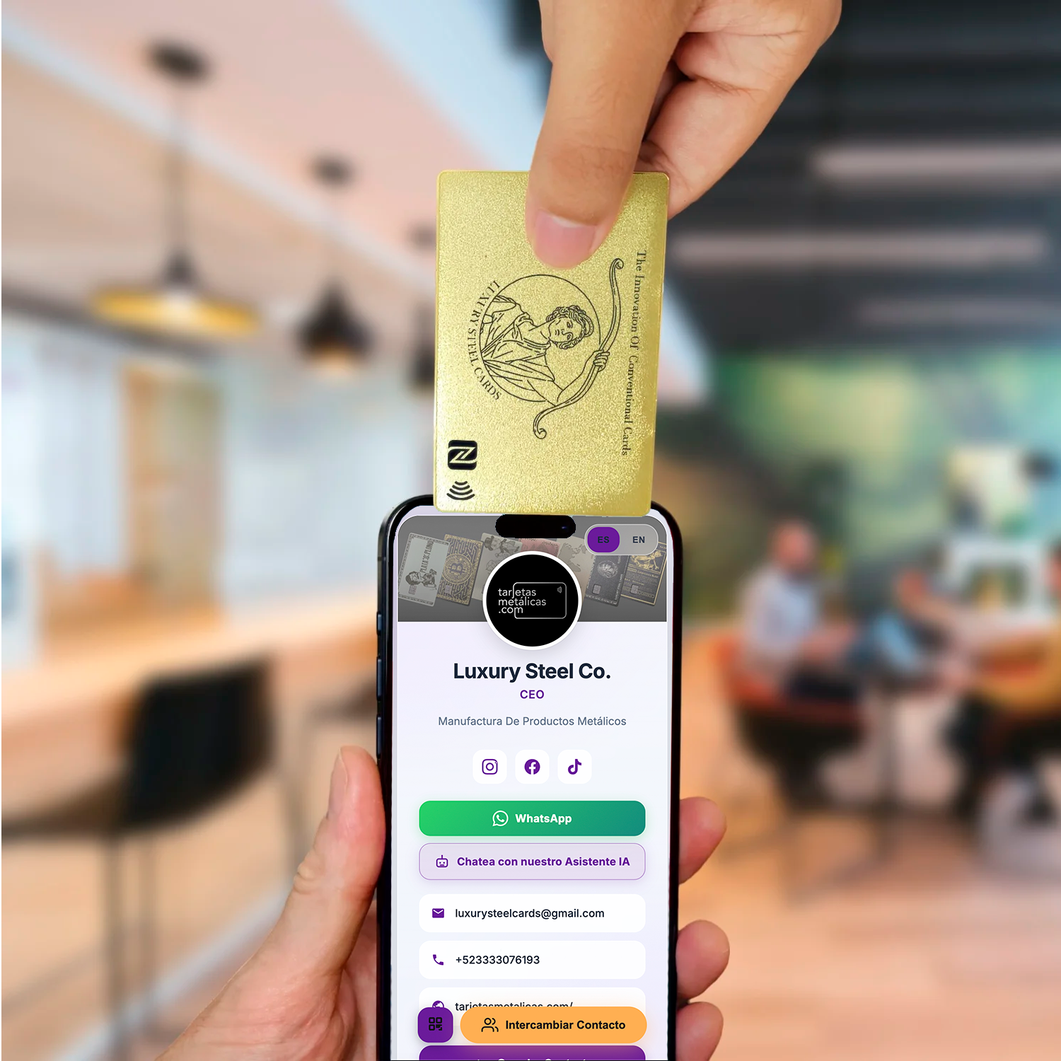 Tarjeta metálica de presentación con NFC en acabado oro, acercada a un teléfono que muestra un perfil digital de contacto